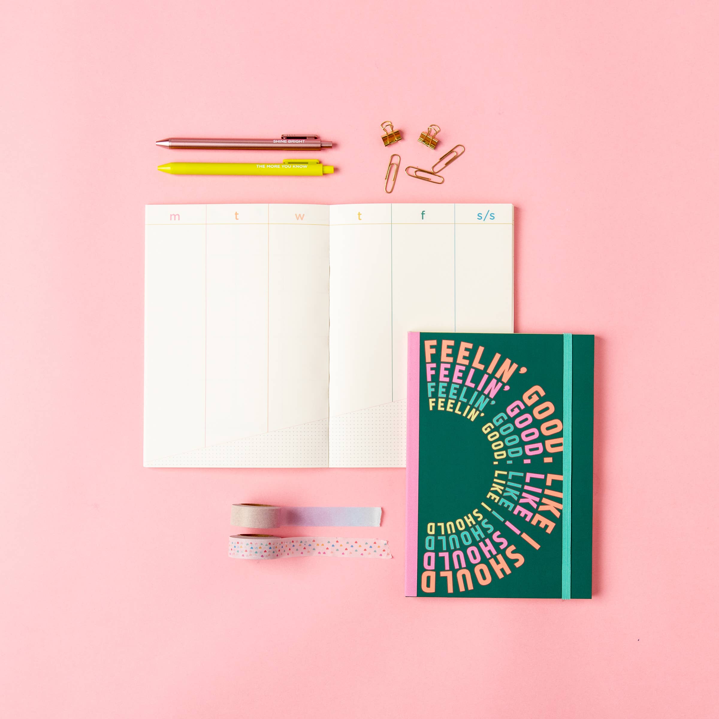 Notebook with colorful text design on a pink background