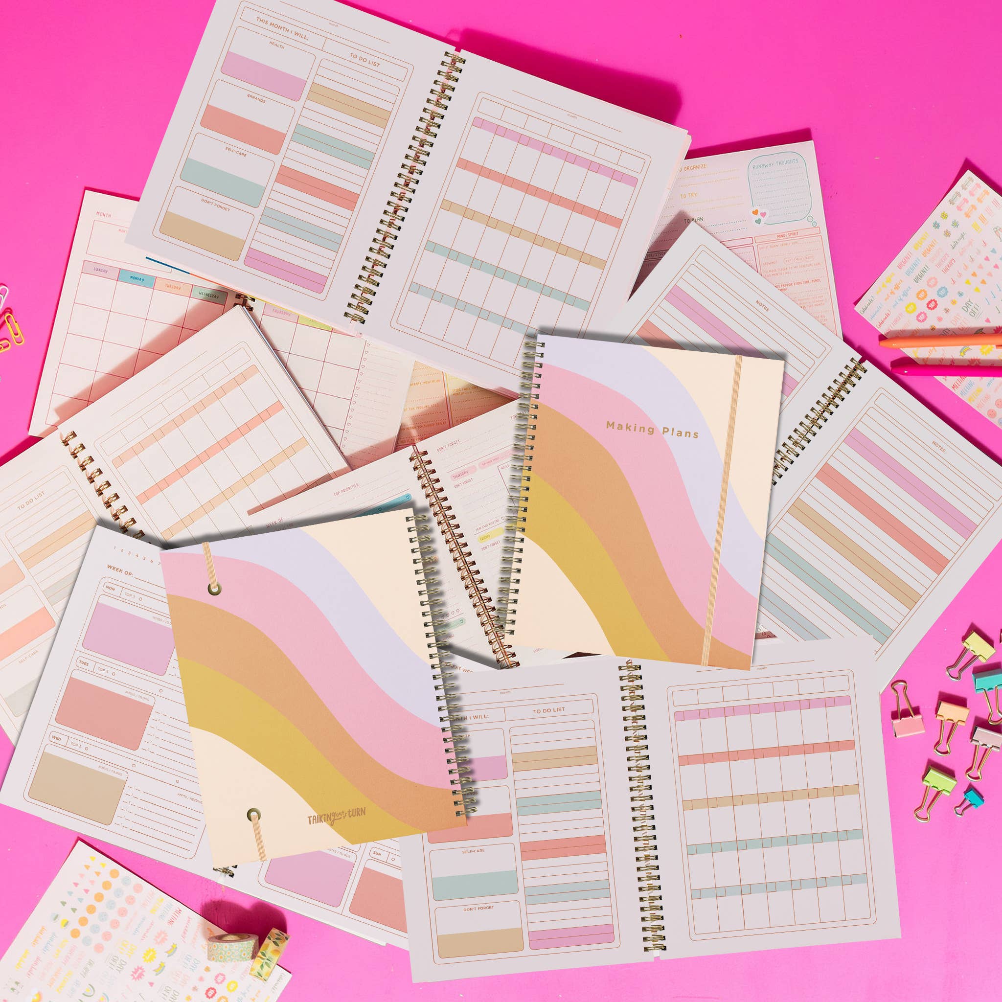 Colorful planners and organizers on a pink background