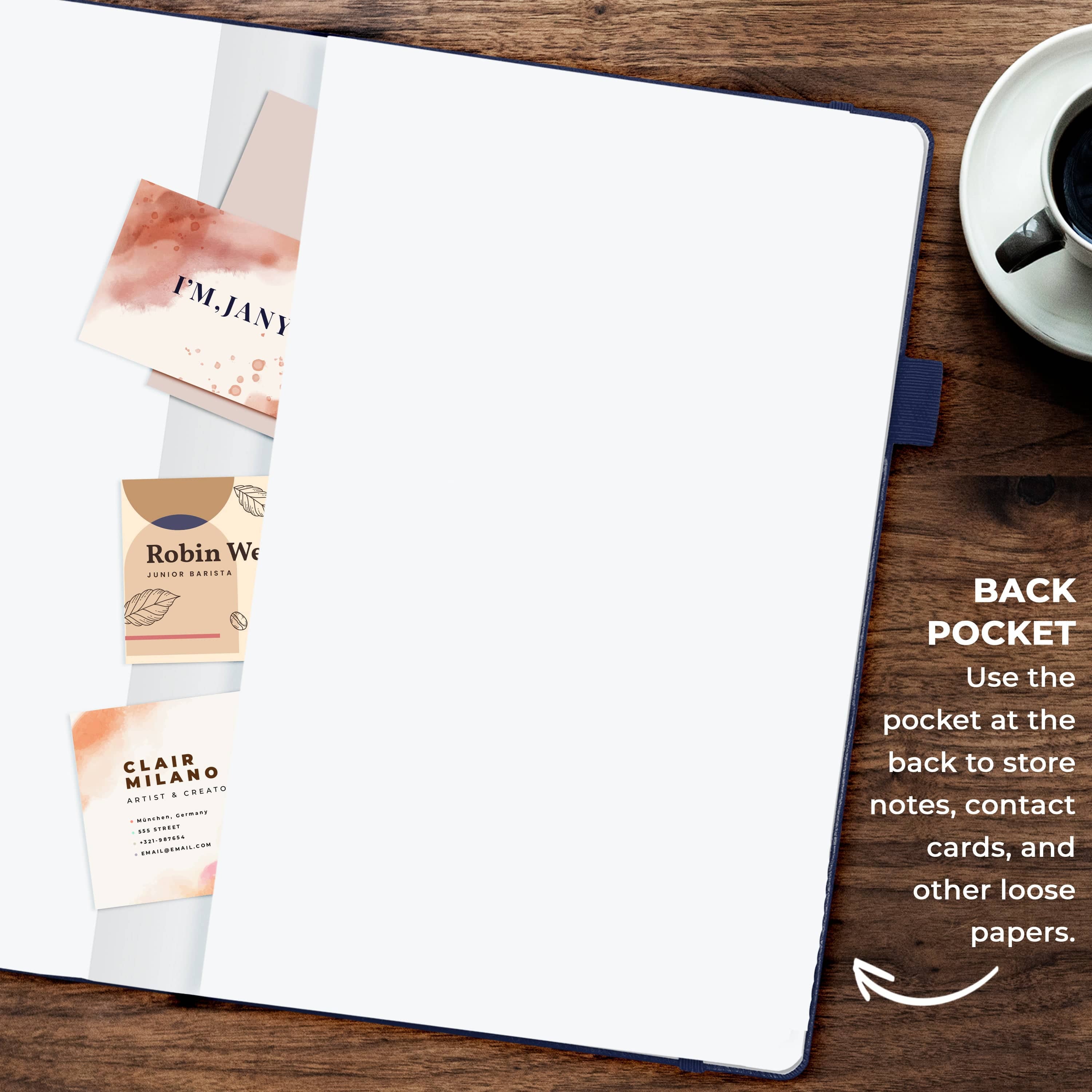 A white notebook or planner page spread open on a dark wood tabletop, with a few business cards tucked into the left side and a coffee cup partially visible in the upper right. Text on the right explains the back pocket and shows its use for notes, contact cards, and loose papers.