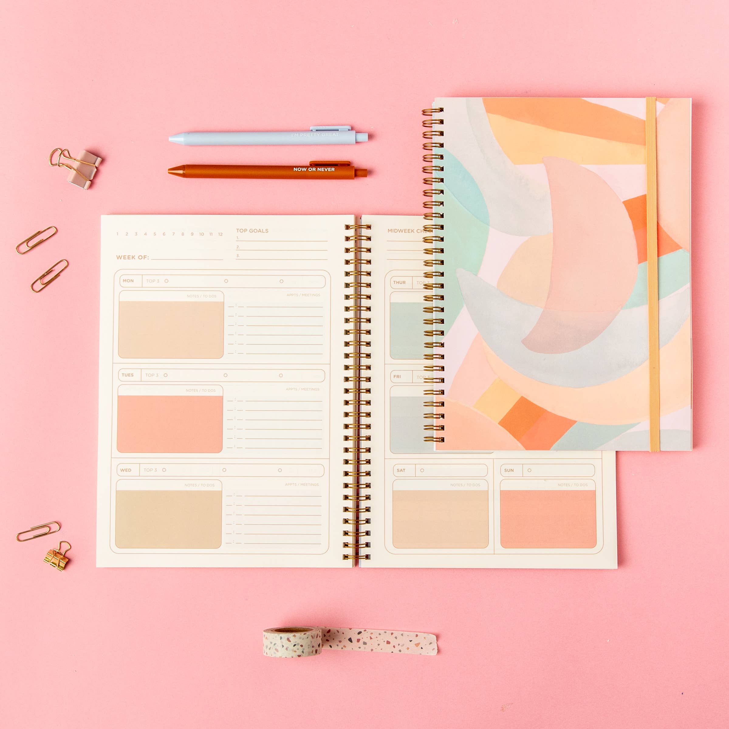 Open planner with colorful abstract design on pink background