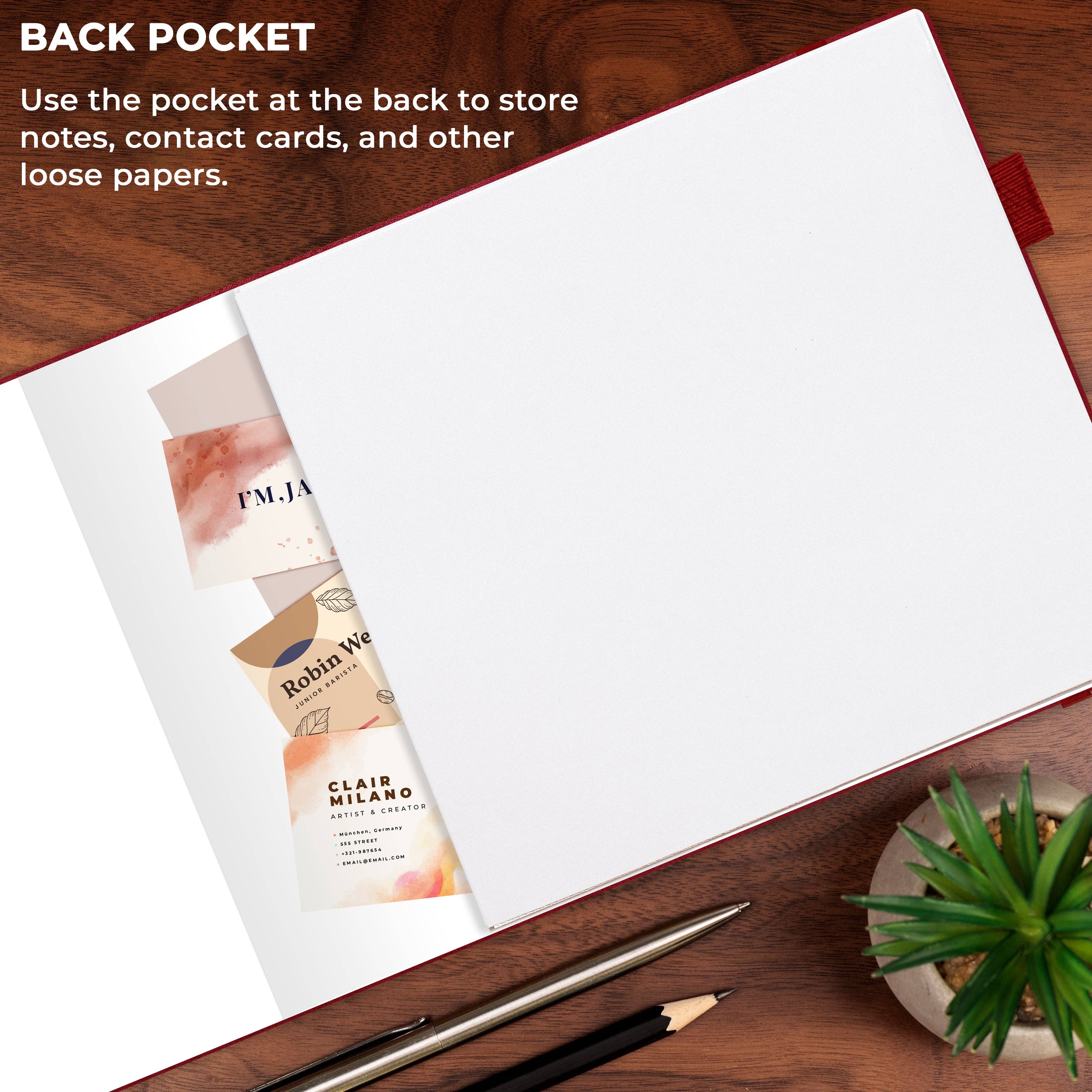 An open notebook or journal on a wooden desk with a text overlay explaining the back pocket feature. The notebook has blank white pages and a few sample contact cards peeking out from the left side.